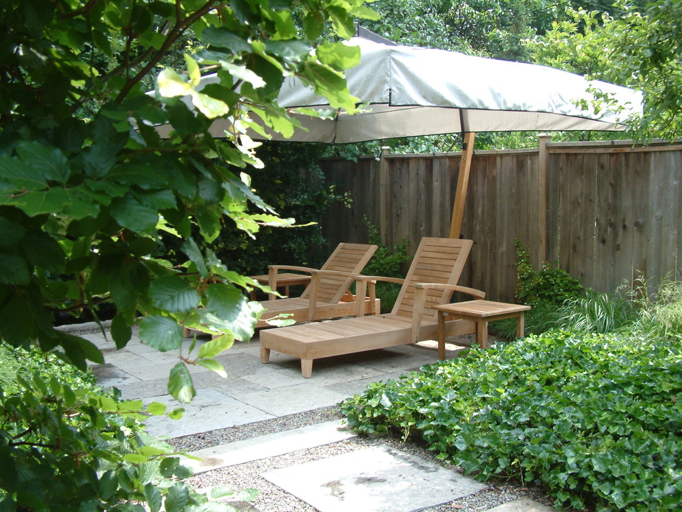 Photo of a small contemporary backyard shaded formal garden for spring in Toronto with natural stone pavers.
