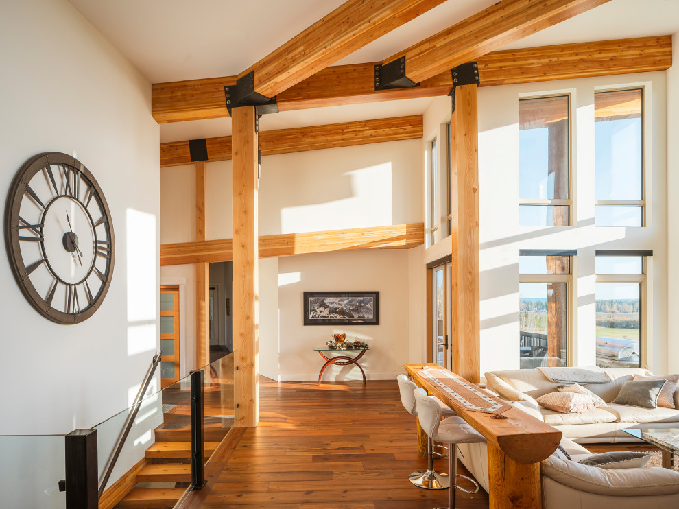 Photo of an expansive contemporary open concept living room in Vancouver with white walls, medium hardwood floors, a corner fireplace, a wall-mounted tv, brown floor and exposed beam.