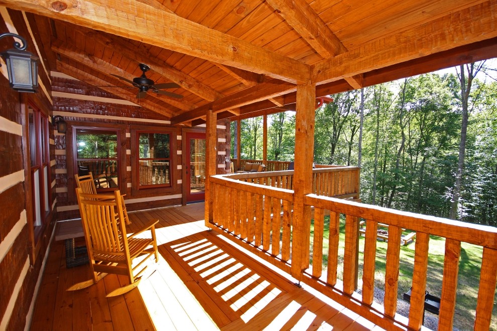 Inspiration for a large rustic backyard deck remodel in Columbus with a fire pit and a roof extension