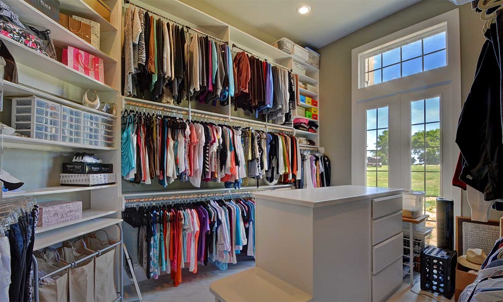 Photo of an expansive eclectic women's walk-in wardrobe in Dallas with flat-panel cabinets, white cabinets and porcelain floors.