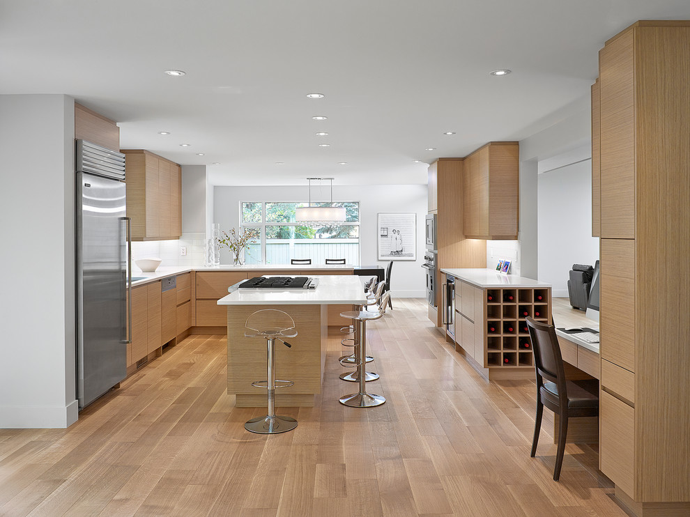 Inspiration for a contemporary l-shaped eat-in kitchen in Edmonton with stainless steel appliances, flat-panel cabinets and light wood cabinets.
