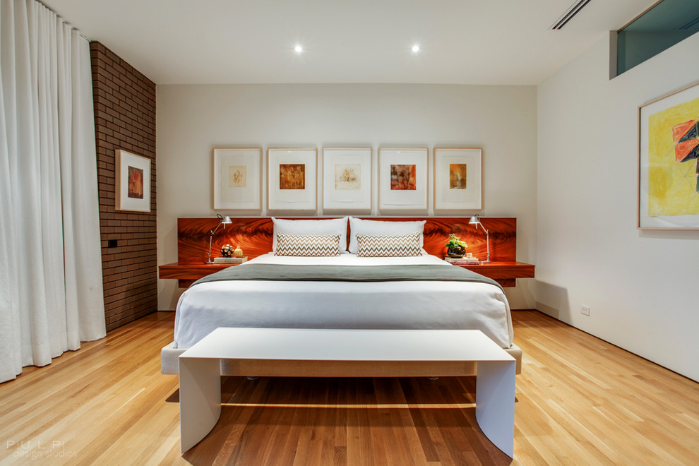 Contemporary master bedroom in Seattle with white walls and light hardwood floors.
