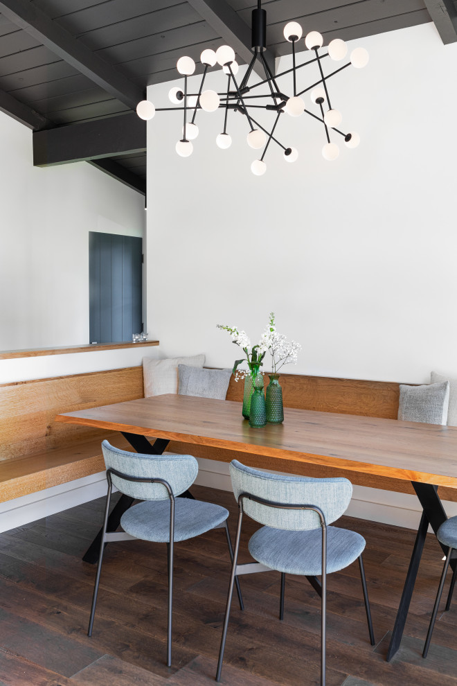 Idées déco pour une salle à manger rétro en bois de taille moyenne avec une banquette d'angle, un mur blanc, parquet foncé, un sol marron et un plafond voûté.