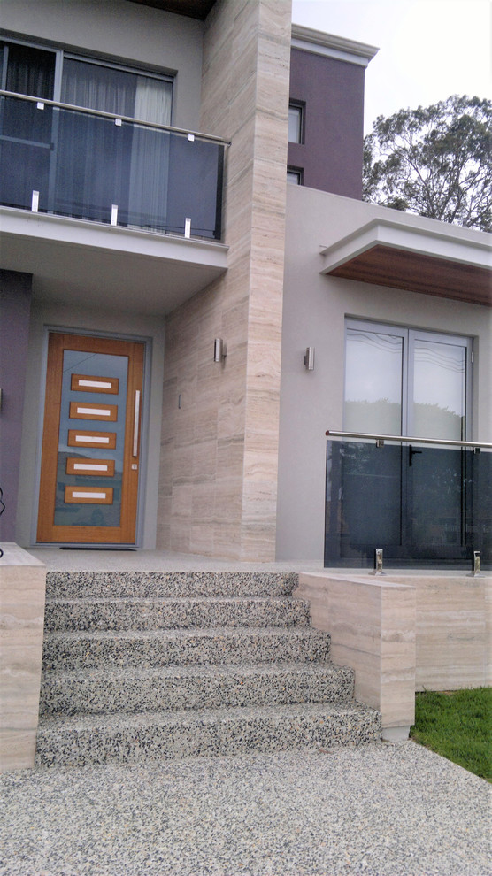 Large contemporary two-storey beige house exterior in Perth with stone veneer, a gable roof and a metal roof.