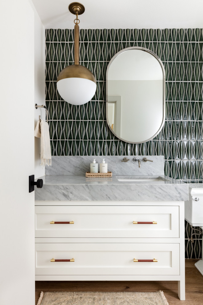 This is an example of a mid-sized contemporary powder room in Richmond with shaker cabinets, white cabinets, medium hardwood floors, an undermount sink and a built-in vanity.