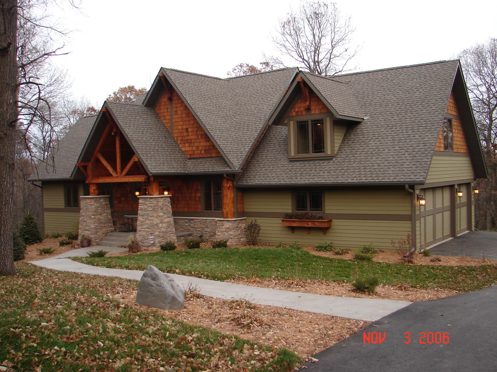 This is an example of a large country two-storey green exterior in Minneapolis with mixed siding.