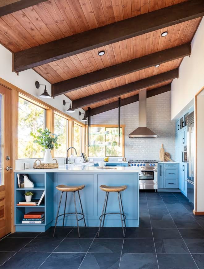 Design ideas for a large modern u-shaped kitchen in Seattle with slate floors, a peninsula, black floor, shaker cabinets, blue cabinets, white splashback, white benchtop, a farmhouse sink, quartzite benchtops, subway tile splashback and stainless steel appliances.
