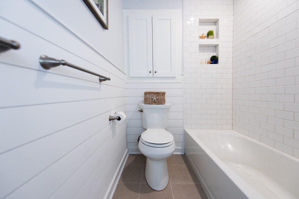 Bathroom - small coastal master gray tile and stone tile ceramic tile, single-sink and shiplap wall bathroom idea in Philadelphia with shaker cabinets, white cabinets, a two-piece toilet, an undermount sink, quartz countertops, white countertops, a niche and a built-in vanity