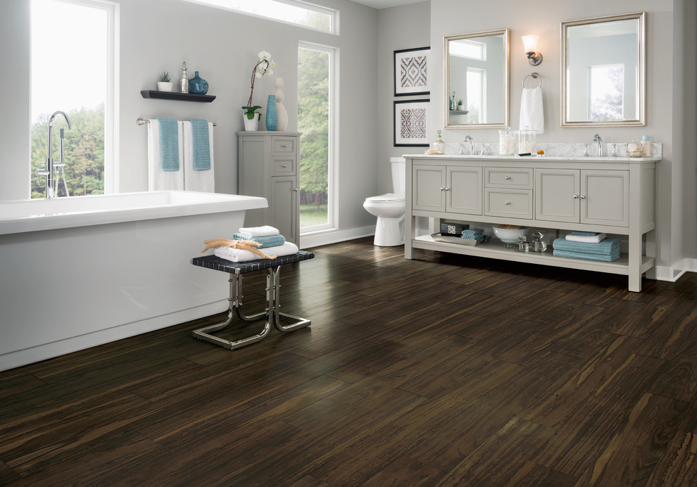 Freestanding bathtub - large transitional master dark wood floor freestanding bathtub idea with recessed-panel cabinets, gray cabinets, gray walls, an undermount sink and marble countertops