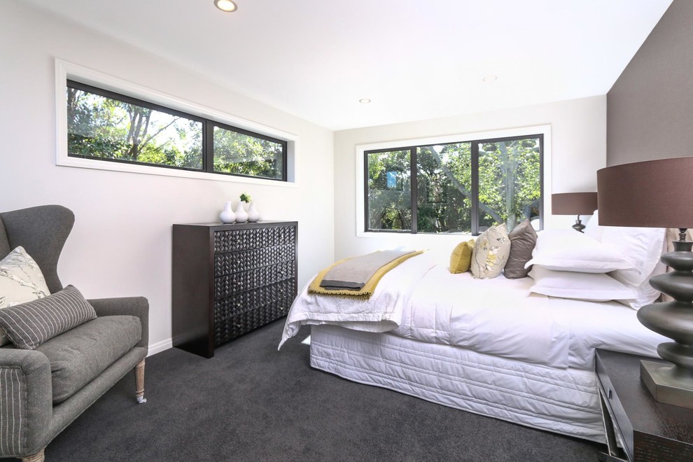 Photo of a mid-sized contemporary master bedroom in Auckland with brown walls, carpet, no fireplace and grey floor.