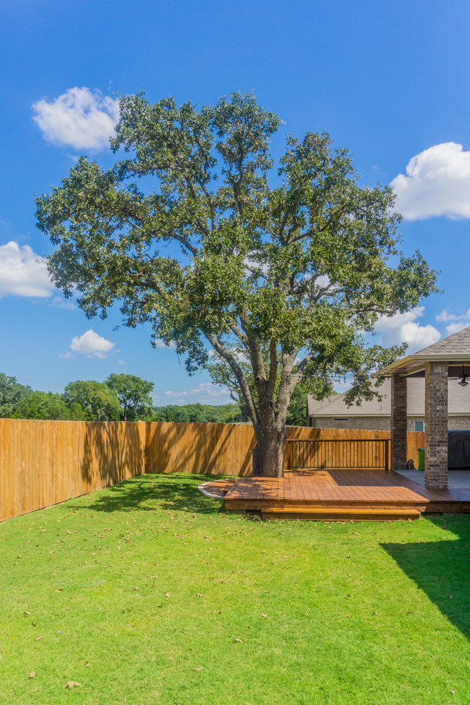 Mid-sized mountain style backyard deck photo in Austin with a roof extension