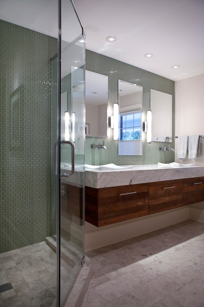Design ideas for a mid-sized contemporary master bathroom in Atlanta with a vessel sink, flat-panel cabinets, medium wood cabinets, marble benchtops, a corner shower, green tile, glass tile, white walls and travertine floors.