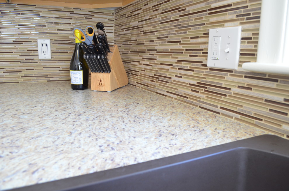 Small transitional kitchen photo with a drop-in sink, raised-panel cabinets, white cabinets, laminate countertops, multicolored backsplash, stainless steel appliances and green walls