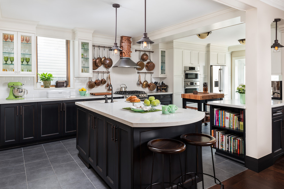Photo of a transitional kitchen in Toronto with recessed-panel cabinets, quartz benchtops, white splashback, ceramic splashback, stainless steel appliances, black cabinets and multiple islands.