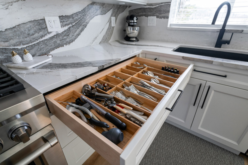 Inspiration for a mid-sized transitional u-shaped medium tone wood floor and brown floor eat-in kitchen remodel with an undermount sink, recessed-panel cabinets, white cabinets, quartz countertops, white backsplash, stone slab backsplash, stainless steel appliances, an island and white countertops