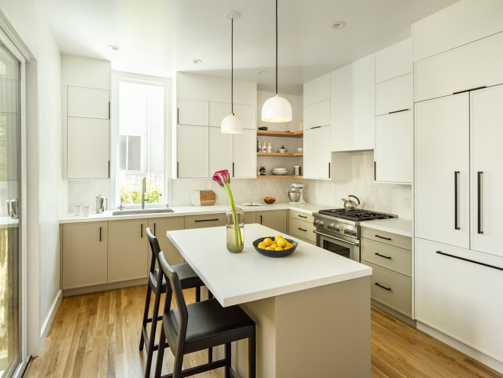 Bild på ett mellanstort funkis vit vitt kök, med en undermonterad diskho, luckor med infälld panel, vita skåp, bänkskiva i kvarts, grått stänkskydd, stänkskydd i keramik, rostfria vitvaror, mellanmörkt trägolv och en köksö