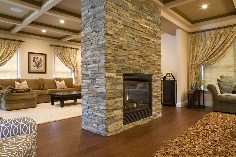 Photo of a large contemporary formal enclosed living room in New York with beige walls, dark hardwood floors, a two-sided fireplace, a stone fireplace surround, no tv and brown floor.