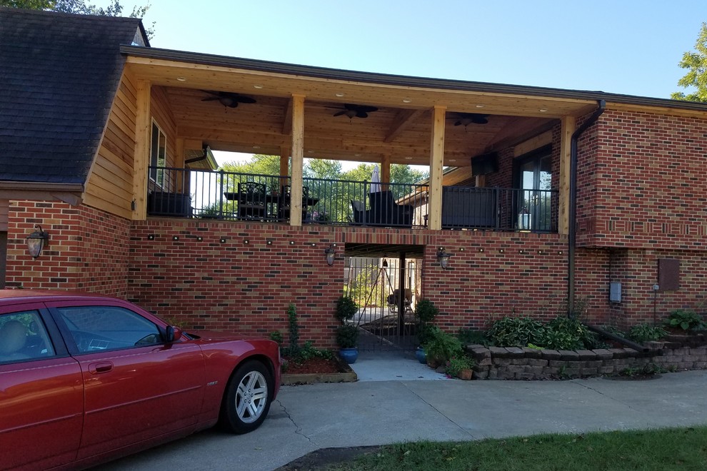 Example of a large backyard deck design with a roof extension