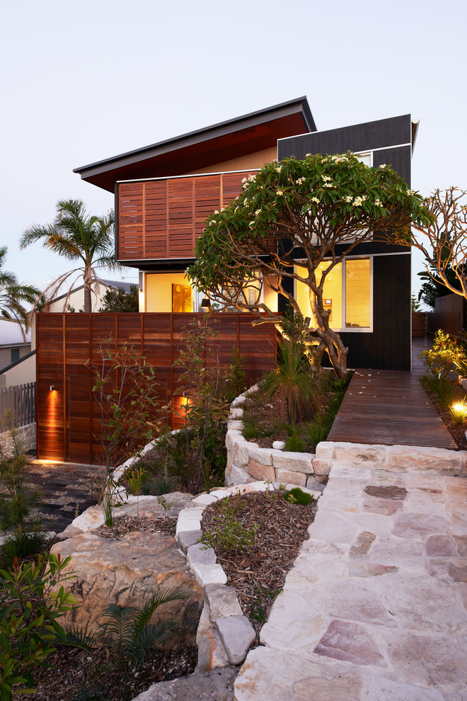 Photo of a mid-sized contemporary three-storey black exterior in Sydney with wood siding and a shed roof.