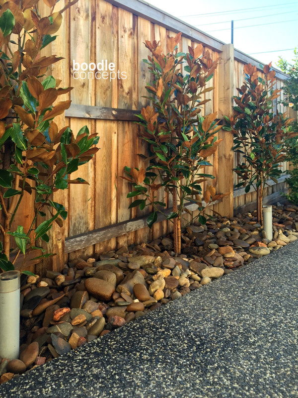 This is an example of a small contemporary side yard partial sun driveway for winter in Melbourne with gravel.