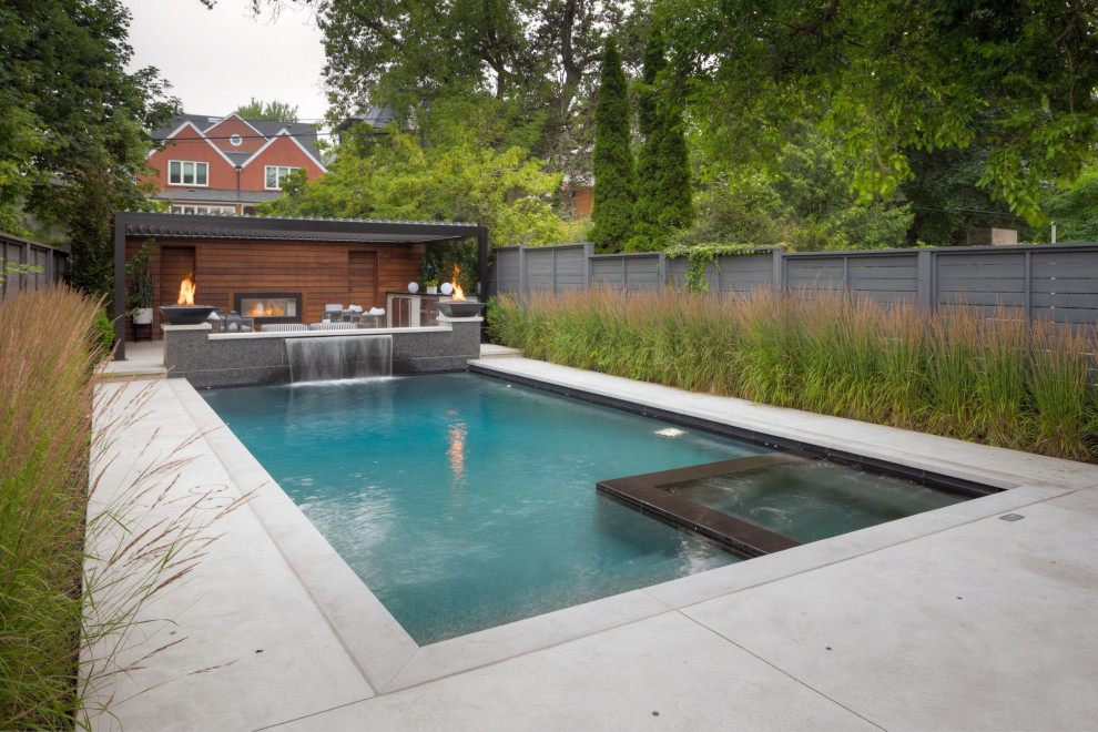 Réalisation d'un petit piscine avec aménagement paysager arrière design rectangle avec du béton estampé.