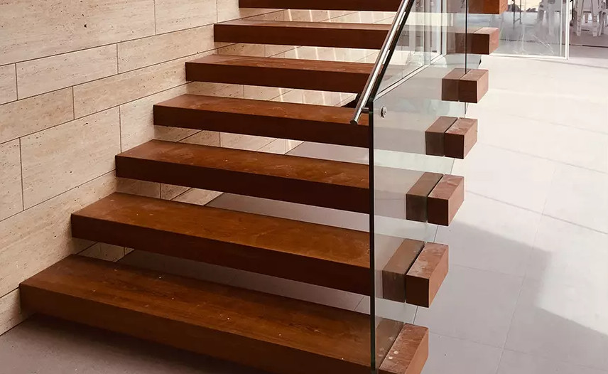 Inspiration for a large industrial metal floating staircase in London with open risers, metal railing and brick walls.