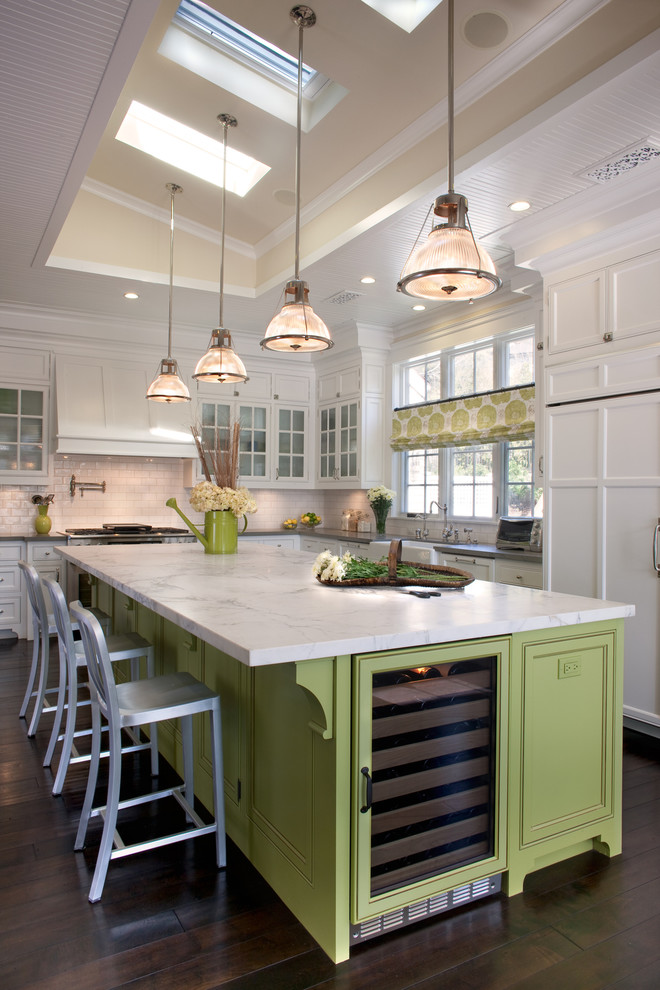 Design ideas for a large traditional u-shaped kitchen in San Diego with a farmhouse sink, beaded inset cabinets, white cabinets, white splashback, subway tile splashback, stainless steel appliances, dark hardwood floors, with island and marble benchtops.