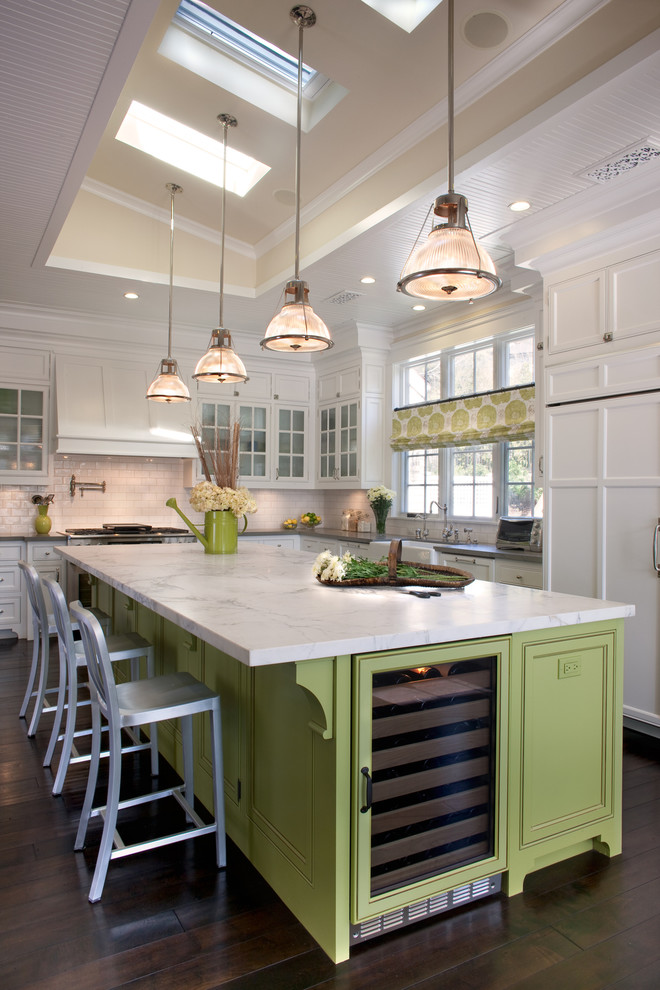 West Coast Hamptons - The kitchen, breakfast room and family room are all open to one another. The kitchen has a large twelve foot island topped with Calacatta marble and features a roll-out kneading table, and room to seat the whole family. The sunlight breakfast room opens onto the patio which has a built-in barbeque, and both bar top seating and a built in bench for outdoor dining. The large family room features a cozy fireplace, TV media, and a large built-in bookcase. The adjoining craft room is separated by a set of pocket french doors; where the kids can be visible from the family room as they do their homework.