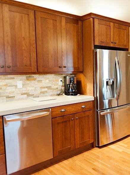 Inspiration for a mid-sized craftsman u-shaped light wood floor eat-in kitchen remodel in Chicago with an undermount sink, shaker cabinets, dark wood cabinets, quartz countertops, beige backsplash, matchstick tile backsplash, stainless steel appliances and a peninsula