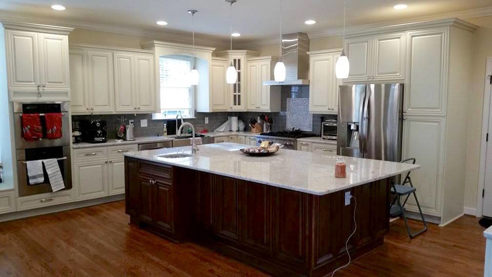 Eat-in kitchen - large transitional l-shaped dark wood floor and brown floor eat-in kitchen idea in Miami with a farmhouse sink, raised-panel cabinets, white cabinets, stainless steel appliances, an island, gray backsplash and subway tile backsplash