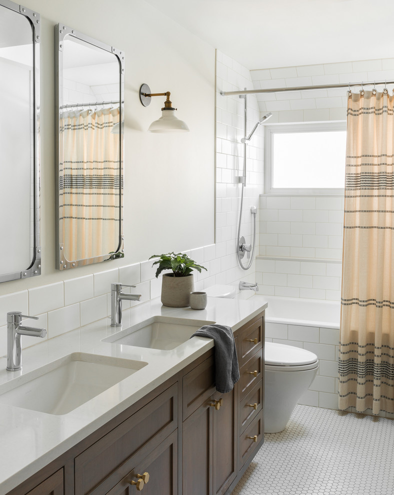 Transitional bathroom in Seattle with shaker cabinets, dark wood cabinets, an alcove tub, a shower/bathtub combo, white tile, subway tile, white walls, mosaic tile floors, an undermount sink, white floor, a shower curtain and white benchtops.