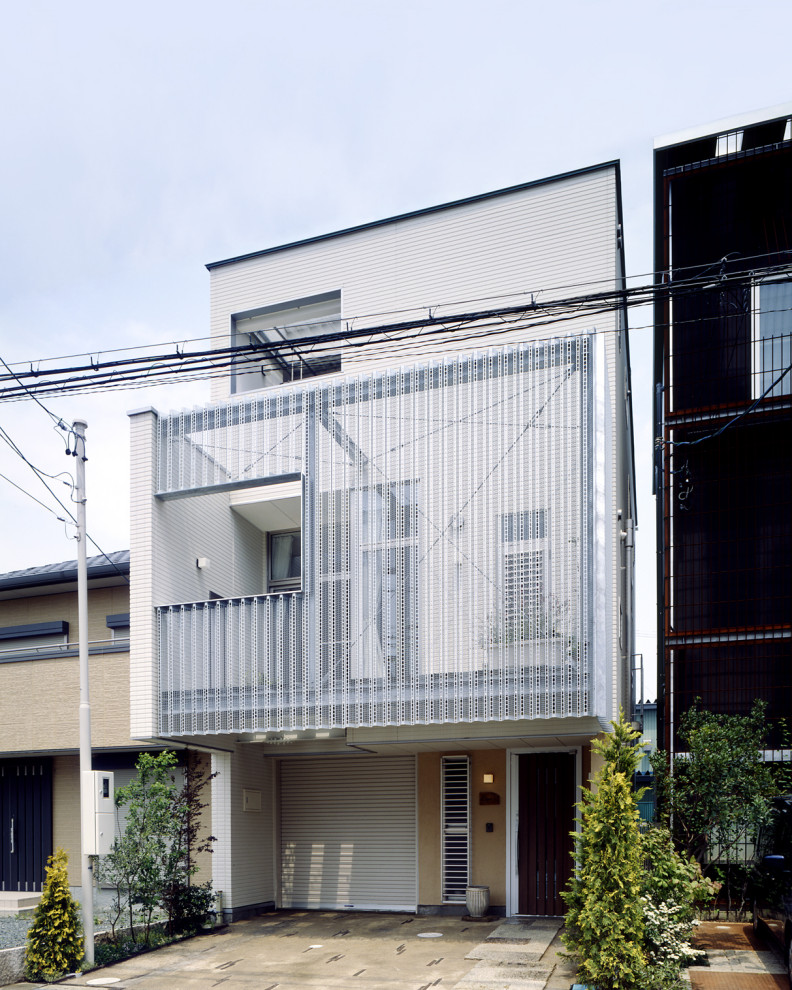 他の地域にある中くらいなモダンスタイルのおしゃれな三階建ての家 (塗装レンガ、長方形) の写真