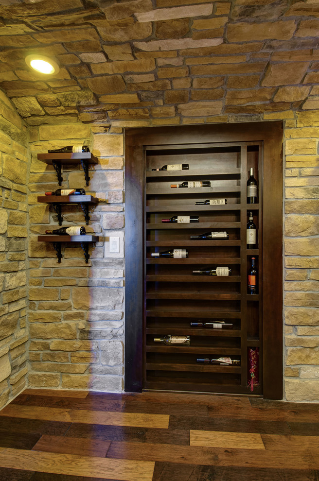 Design ideas for a mid-sized traditional wine cellar in Denver with dark hardwood floors, display racks and multi-coloured floor.