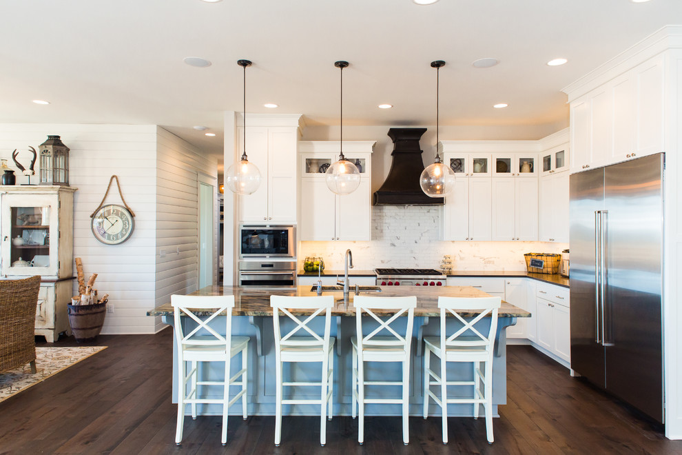 Design ideas for a mid-sized country l-shaped open plan kitchen in Portland with shaker cabinets, white cabinets, quartz benchtops, stainless steel appliances, dark hardwood floors, with island, brown floor, black benchtop, an undermount sink and white splashback.