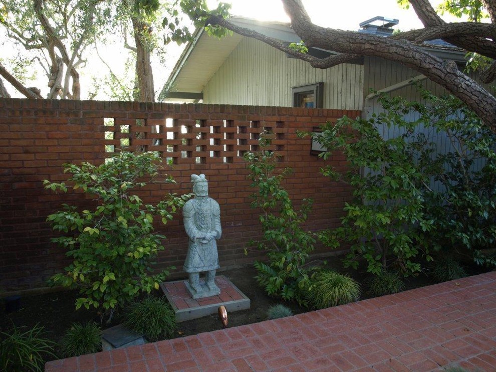 This is an example of a large asian backyard patio in San Diego with a fire feature, tile and a roof extension.