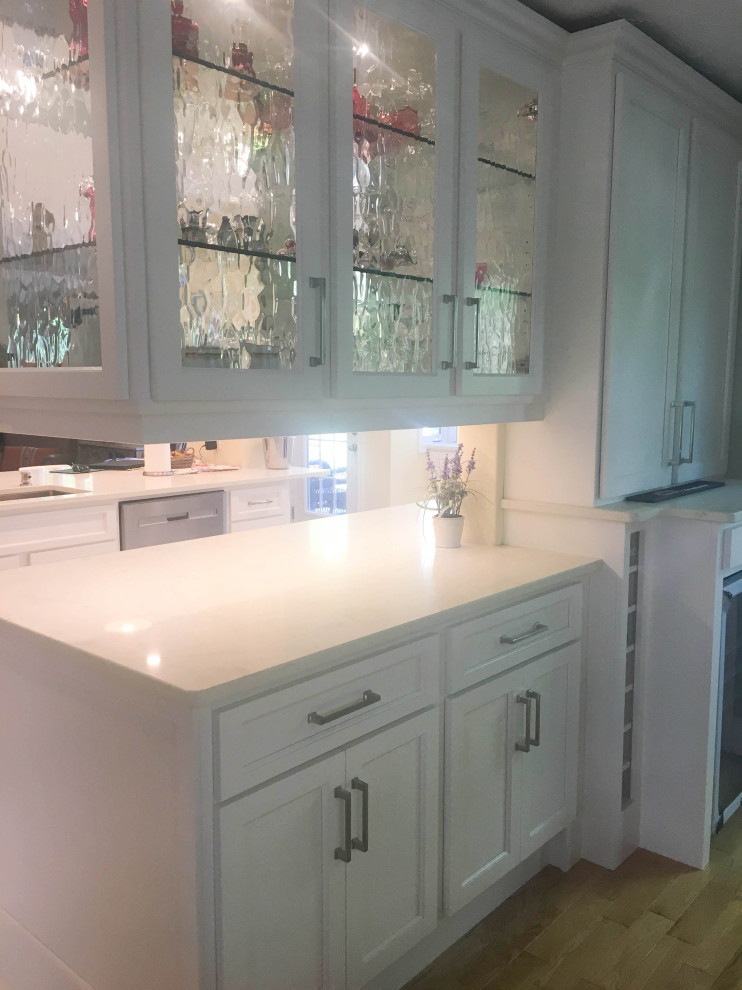 Mid-sized transitional u-shaped porcelain tile and gray floor eat-in kitchen photo with an undermount sink, shaker cabinets, white cabinets, quartz countertops, white backsplash, subway tile backsplash, stainless steel appliances, a peninsula and beige countertops