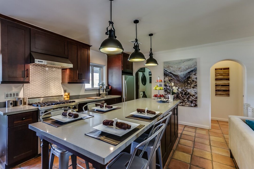 Open concept kitchen - large transitional galley terra-cotta tile and brown floor open concept kitchen idea in Phoenix with an undermount sink, shaker cabinets, dark wood cabinets, quartz countertops, stainless steel appliances and an island