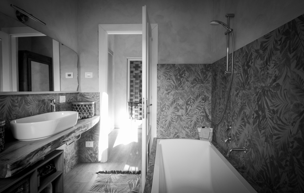 На фото: огромная ванная комната в стиле фьюжн с открытыми фасадами, темными деревянными фасадами, накладной ванной, инсталляцией, зеленой плиткой, керамогранитной плиткой, розовыми стенами, полом из ламината, настольной раковиной, столешницей из дерева, бежевым полом, тумбой под одну раковину и подвесной тумбой с