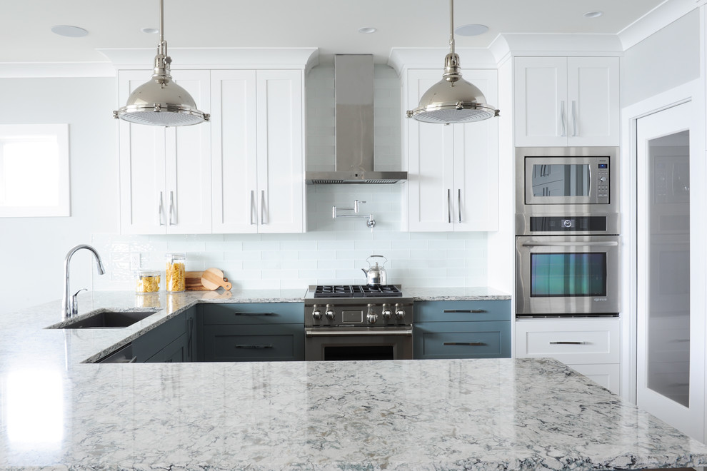 Inspiration for a large transitional u-shaped medium tone wood floor open concept kitchen remodel in Vancouver with an undermount sink, shaker cabinets, white cabinets, quartz countertops, metallic backsplash, glass tile backsplash and stainless steel appliances