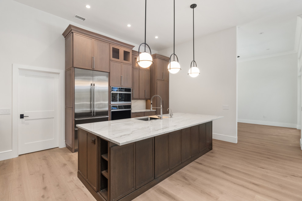 Example of a large transitional galley light wood floor and brown floor eat-in kitchen design in Tampa with a double-bowl sink, shaker cabinets, dark wood cabinets, quartz countertops, gray backsplash, stone slab backsplash, stainless steel appliances, an island and gray countertops