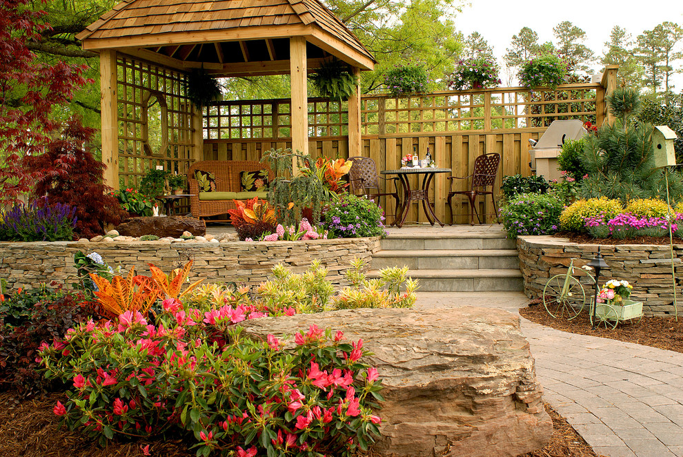 Inspiration for a mid-sized rustic full sun backyard stone retaining wall landscape for spring.