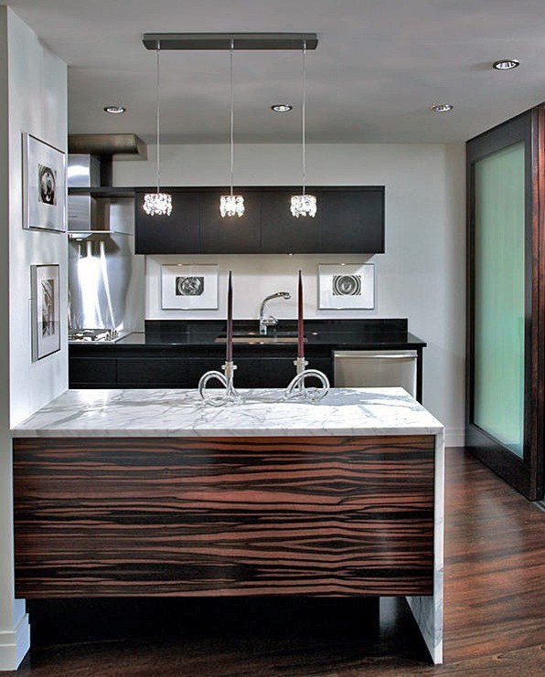 Photo of a contemporary l-shaped eat-in kitchen in DC Metro with an undermount sink, flat-panel cabinets, dark wood cabinets, marble benchtops, black splashback, stone slab splashback and stainless steel appliances.
