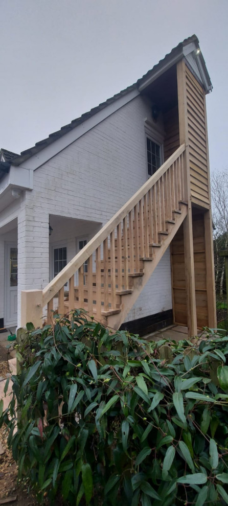 Foto de escalera recta clásica grande con escalones de madera, contrahuellas de madera, barandilla de madera y madera