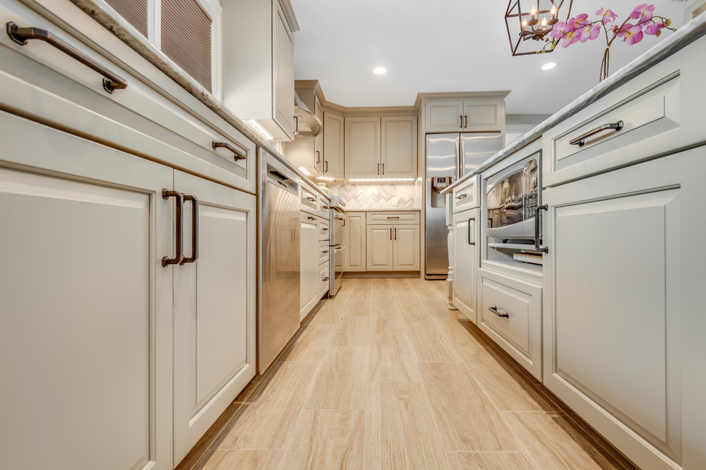 Design ideas for a mid-sized transitional eat-in kitchen in Boston with an undermount sink, raised-panel cabinets, grey cabinets, quartzite benchtops, multi-coloured splashback, travertine splashback, stainless steel appliances, ceramic floors, with island, beige floor and brown benchtop.