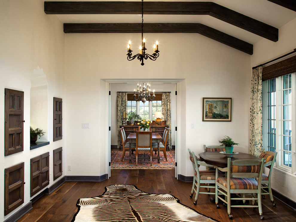 Mid-sized mediterranean dining room in Santa Barbara with white walls, dark hardwood floors and no fireplace.