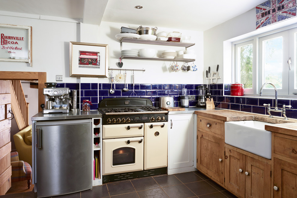 Inspiration for a small country l-shaped separate kitchen in Gloucestershire with shaker cabinets, distressed cabinets, wood benchtops, blue splashback, ceramic splashback, porcelain floors and no island.