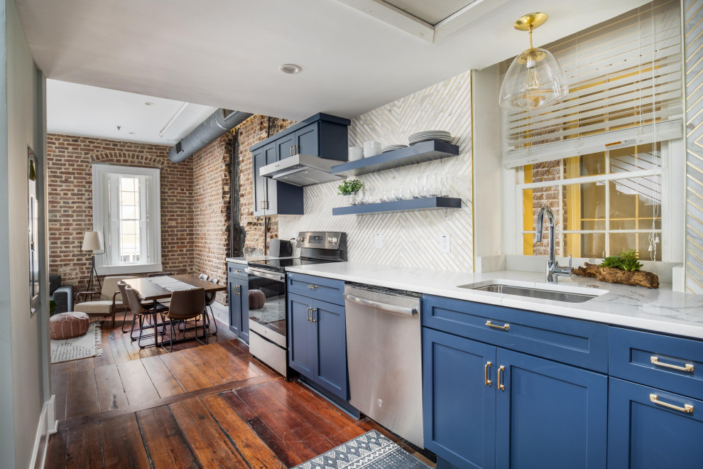 Einzeilige Industrial Küche ohne Insel mit Unterbauwaschbecken, blauen Schränken, Küchengeräten aus Edelstahl und weißer Arbeitsplatte in Charleston