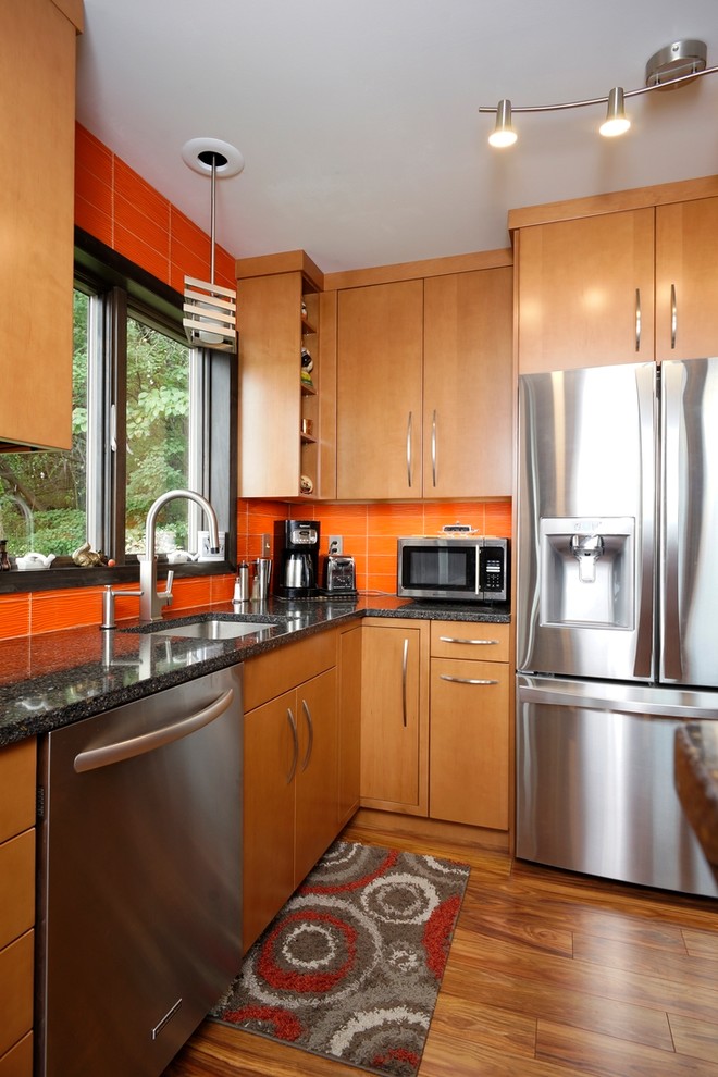 Small contemporary l-shaped separate kitchen in Philadelphia with an undermount sink, flat-panel cabinets, light wood cabinets, quartz benchtops, orange splashback, glass tile splashback, stainless steel appliances, laminate floors, no island, brown floor and blue benchtop.