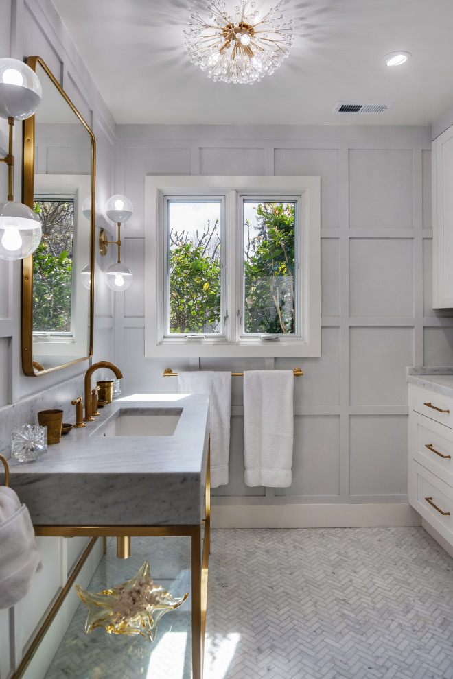 Klassisk inredning av ett mellanstort grå grått badrum, med en dusch i en alkov, en toalettstol med hel cisternkåpa, marmorkakel, marmorgolv, ett integrerad handfat, marmorbänkskiva, grått golv, dusch med gångjärnsdörr, grå skåp, grå kakel och grå väggar