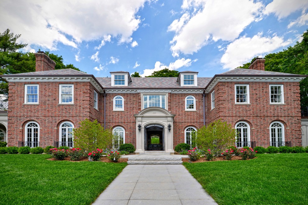 This is an example of an expansive traditional two-storey brick red exterior in Boston with a hip roof.